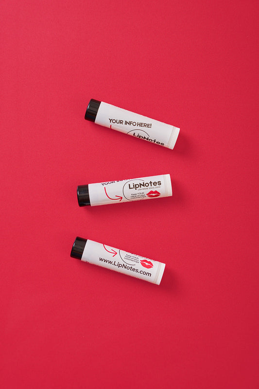 Beeswax-based LipNotes lip balm tubes on a red background