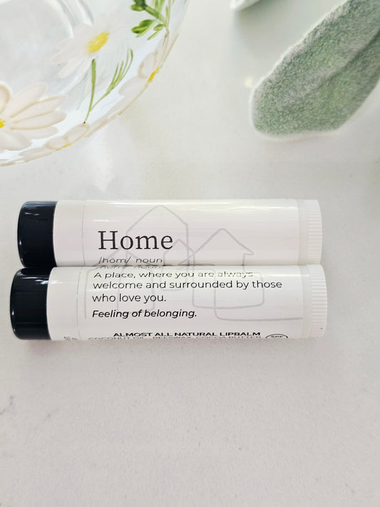 Two lip balms with home labels on a light surface