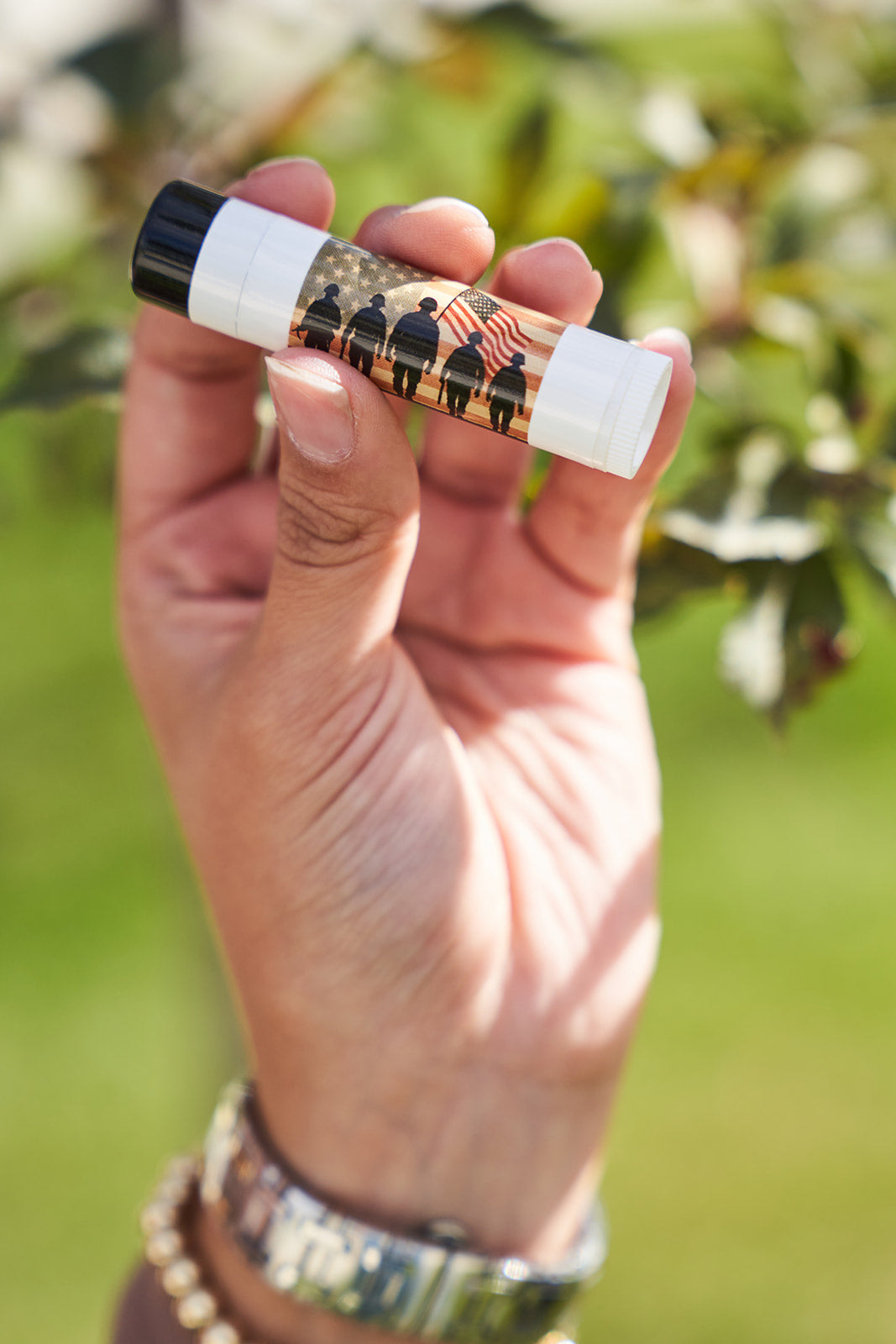 Solider silhouette with an American flag in the back ground that says Honor and Remember. Being held in a womans hand. 